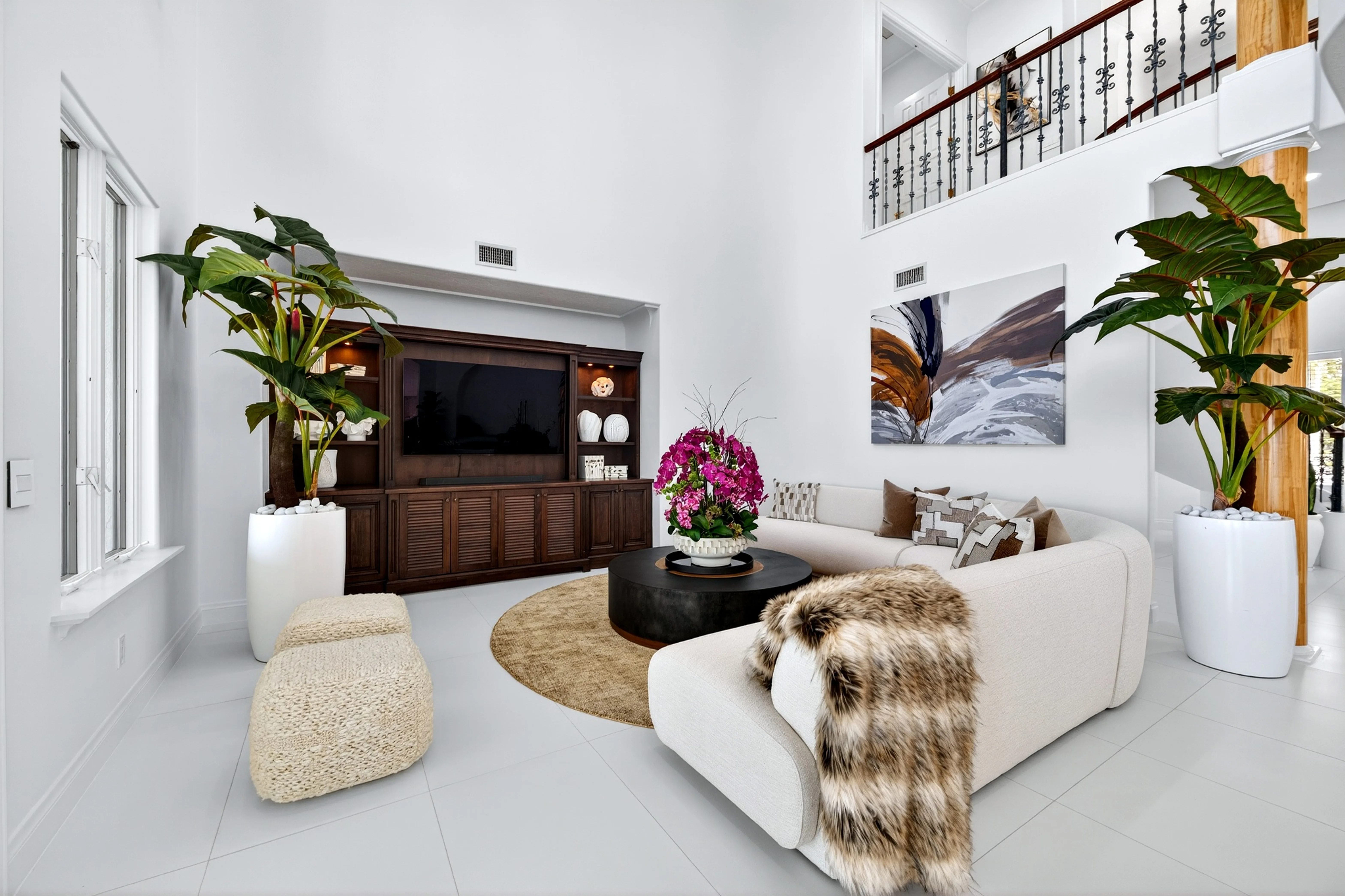 Family den with fireplace media wall and double-height ceiling