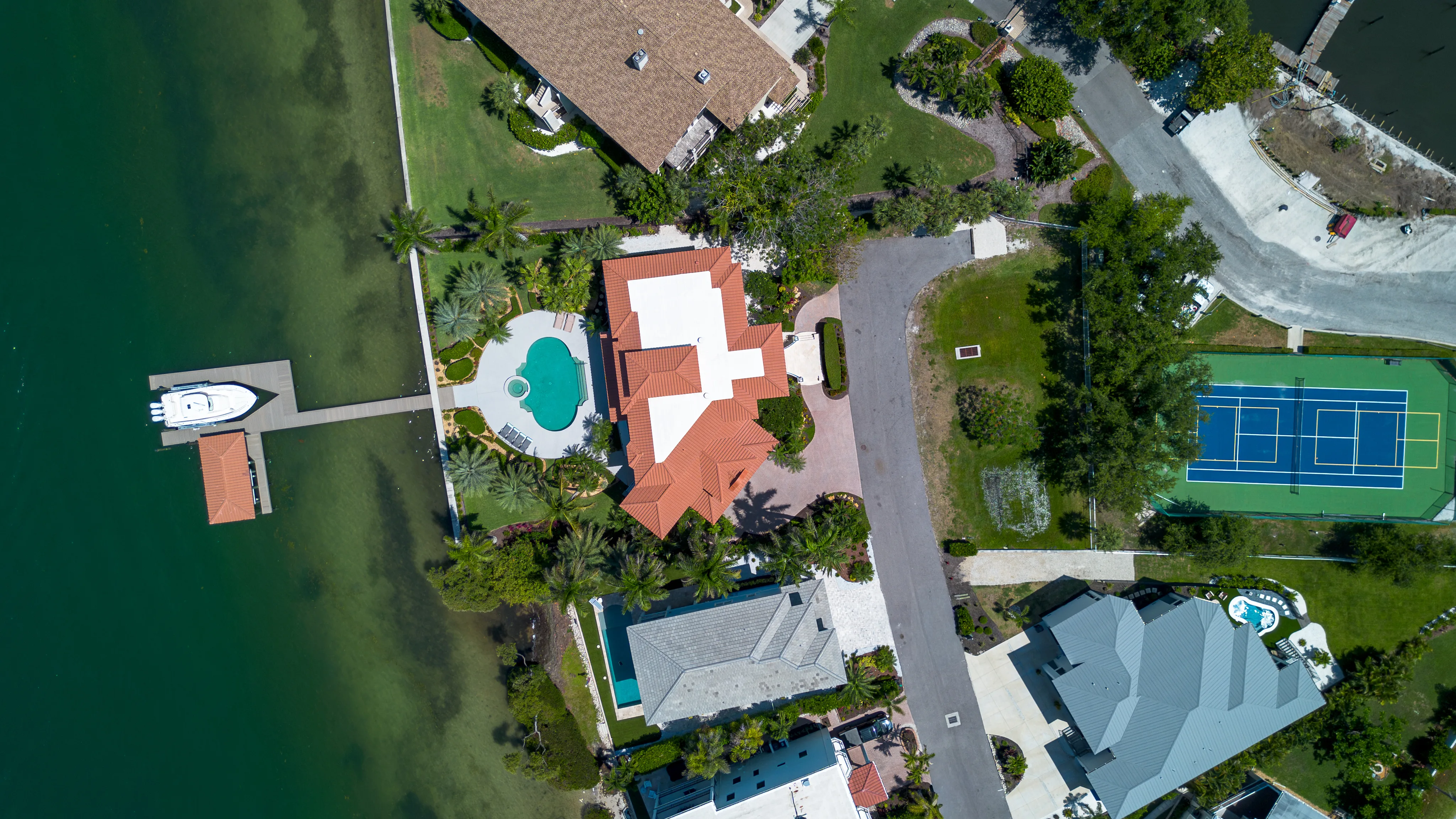 Aerial overhead of the property, dock, and Sunset Harbor